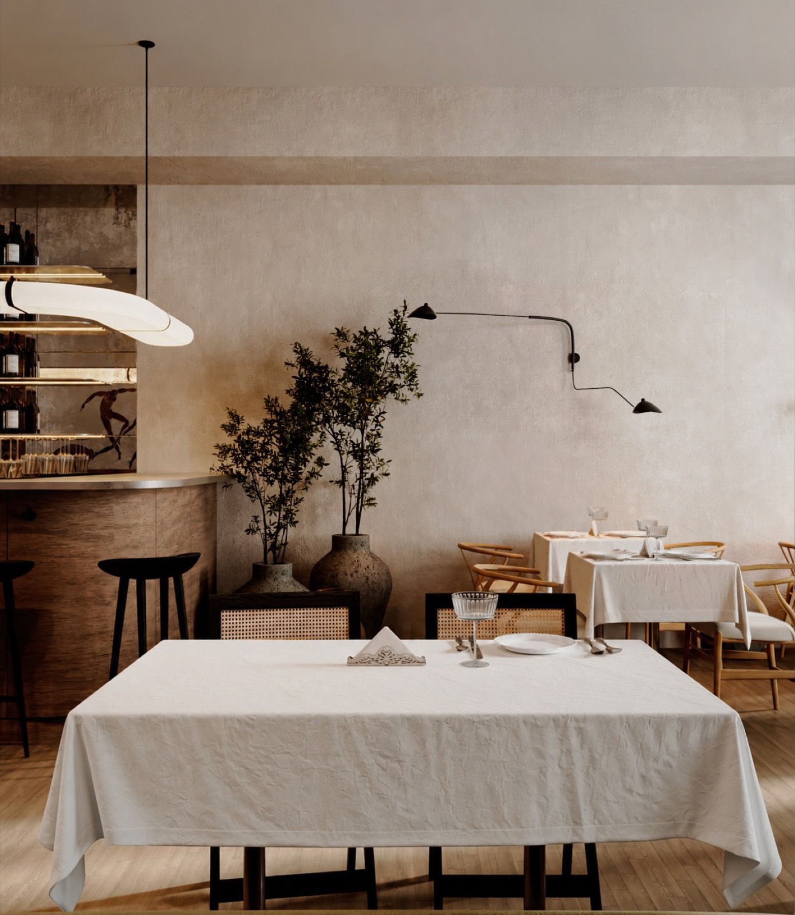 A long linen table set beneath olive trees in the dining room